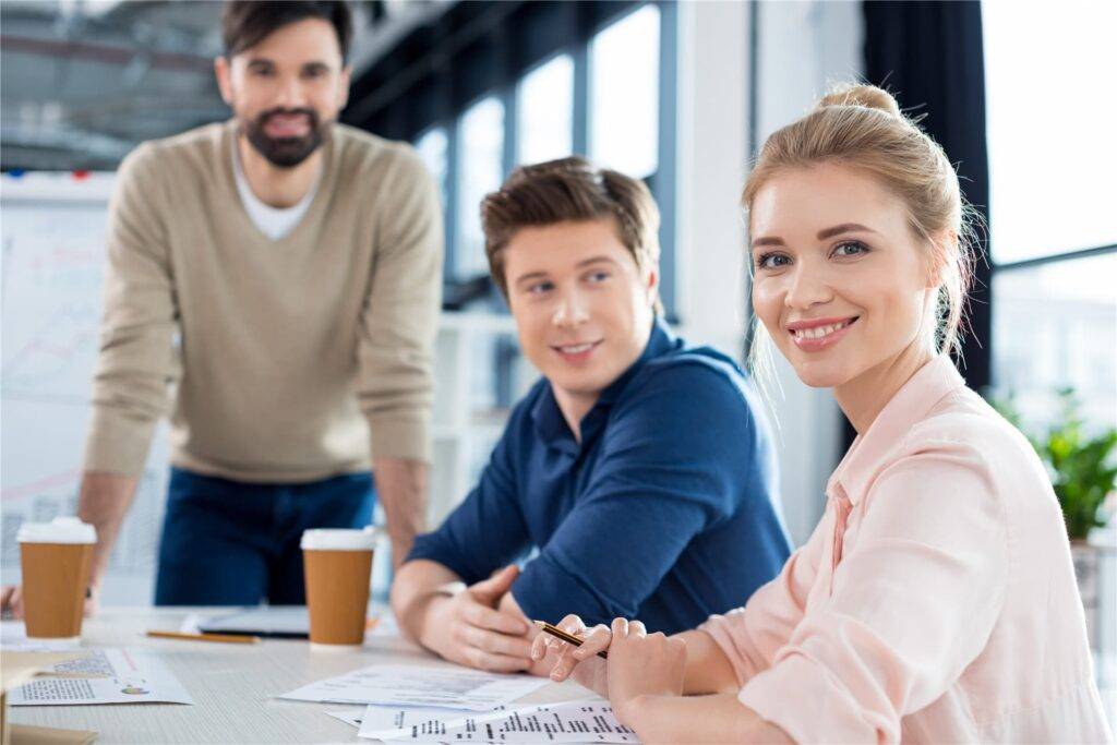 smiling businesswoman sitting at table with collea 2021 08 29 10 49 09 utc