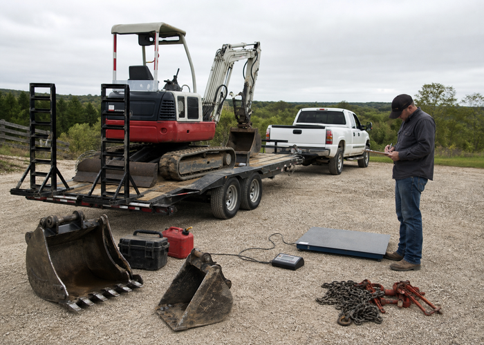 Mini Excavator Trailer Þyngdarskipulag: Vél, fötu, eldsneyti og Tie-Down Basics 2 Rekstraraðili reiknar út flutningsþyngd með litlum gröfum með fötum og keðjum sem eru bundnar